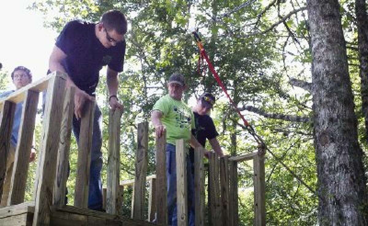 Calvary Baptist School students and volunteers build a zip line at Gospel Lakes Ranch in New Waverly Thursday as part of a community Serve-a-Thon event.