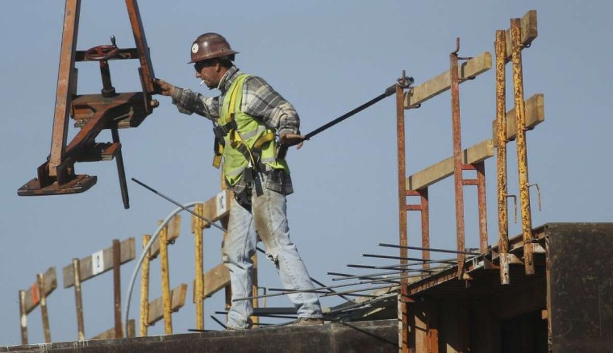 A construction worker directs a steel hoist at the foundation of a new condo complex in Sunrise, Fla., Thursday. A burst of hiring in December pushed the unemployment rate to its lowest level in nearly three years, giving the economy a boost at the end of 2011.
