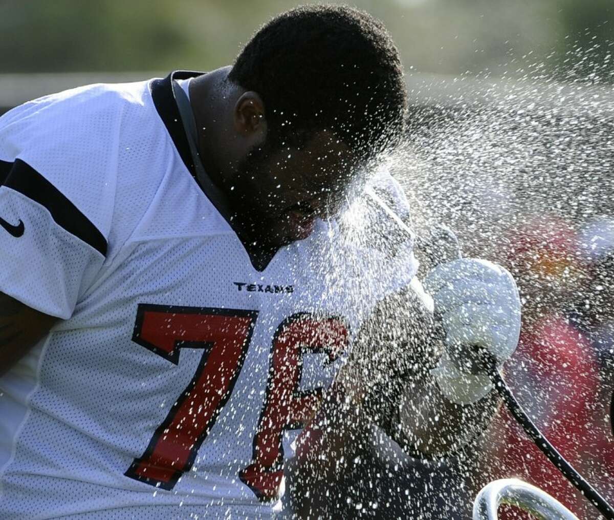 The Houston Texans’ Duane Brown cools off during training camp on July 29 in Houston.