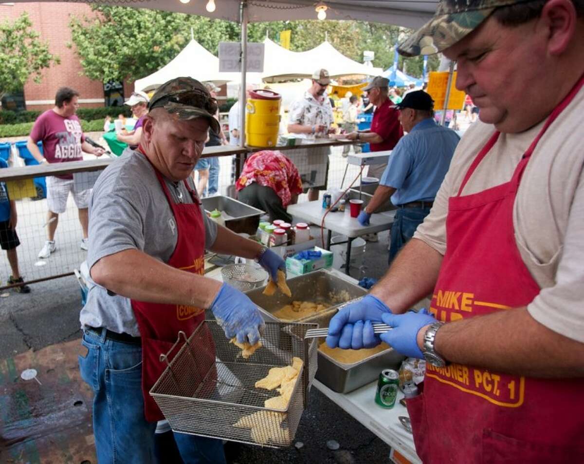 Tim Adamik, left, and Poncho Viniarski with the Knights of Columbus, council 5921 of Willis/New Waverly prepare to fry some catfish during Saturday’s Conroe Cajun Catfish Festival in downtown Conroe.