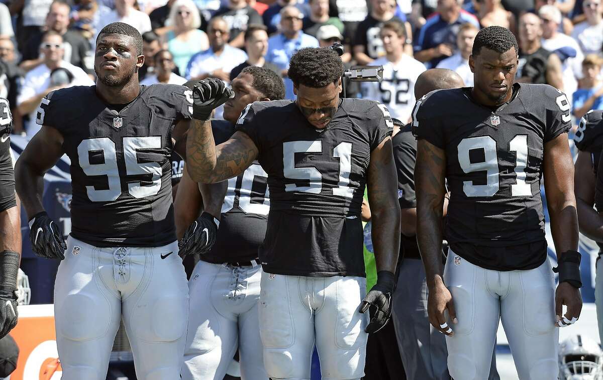 Oakland Raiders outside linebacker Bruce Irvin (51) raises a fist during the playing of the national anthem before an NFL football game against the Tennessee Titans Sunday, Sept. 25, 2016, in Nashville, Tenn. At left is defensive end Jihad Ward (95) and at right is linebacker Shilique Calhoun (91). (AP Photo/Mark Zaleski)