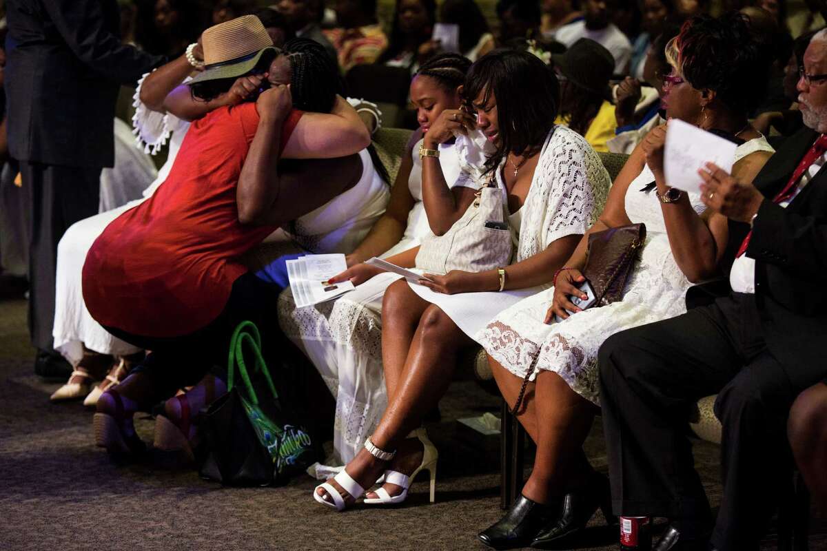 A row of family members sob and are embraced by friends during the funeral for Melvin McKinney, the last of four prisoners who committed suicide in the Bexar County Jail, at True Vision Church on August 2, 2016.