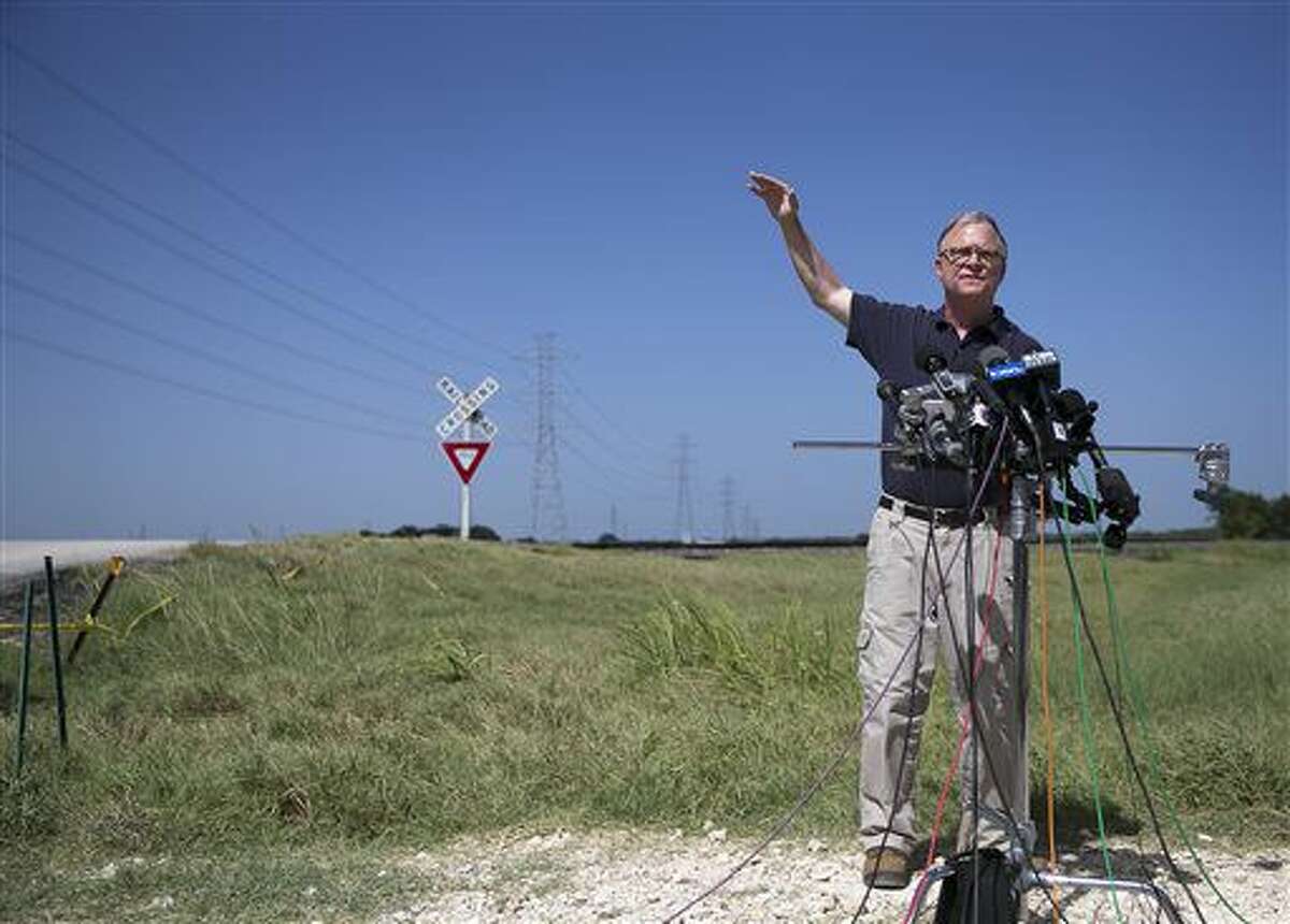 National Transportation Safety Board (NTSB) member Robert Sumwalt talks about power lines, left, during a news conference at the scene of Saturday's hot air balloon crash near Lockhart, Texas, Monday, Aug. 1, 2016. The balloon made contact with the wires. Sixteen people were killed in the crash. (Deborah Cannon/Austin American-Statesman via AP)