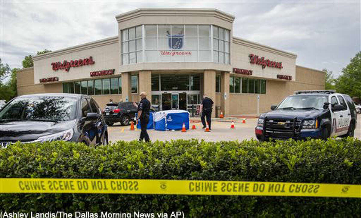 The body of a good samaritan lays under a blue tent after he was fatally shot outside a Walgreens on Monday, May 2, 2016, in Arlington, Texas, after he tried to stop a man who came to confront a woman who worked at the store. Arlington police say Anthony “T.J.” Antell Jr. saw Ricci Bradden shoot at the feet of his wife during an argument Monday outside of the Walgreens where she works, striking her once. Antell retrieved a handgun from his vehicle and confronted Bradden in an attempt to make a citizen’s arrest, but Bradden managed to slap it away and then fatally shot Antell, investigators say. (Ashley Landis/The Dallas Morning News via AP)