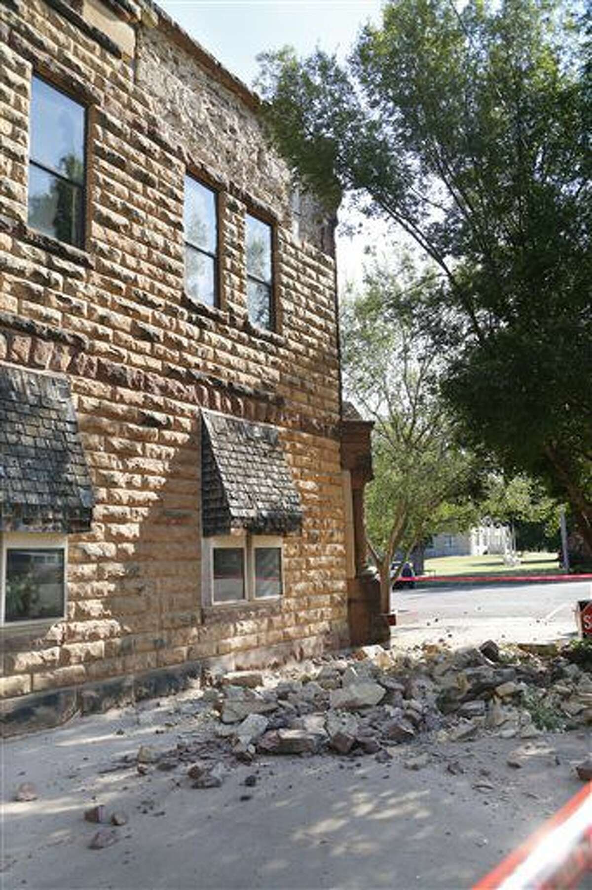 Sandstone bricks from the side of the historic Pawnee County Bank litter the sidewalk after an early morning earthquake in Pawnee, Oka., on Saturday, Sept. 3, 2016. The United States Geological Survey said a 5.6 magnitude earthquake happened Saturday morning in north-central Oklahoma, on the fringe of an area where regulators had stepped in to limit wastewater disposal. That temblor matches a November 2011 quake in the same region. (Paul Hellstern/The Oklahoman via AP)