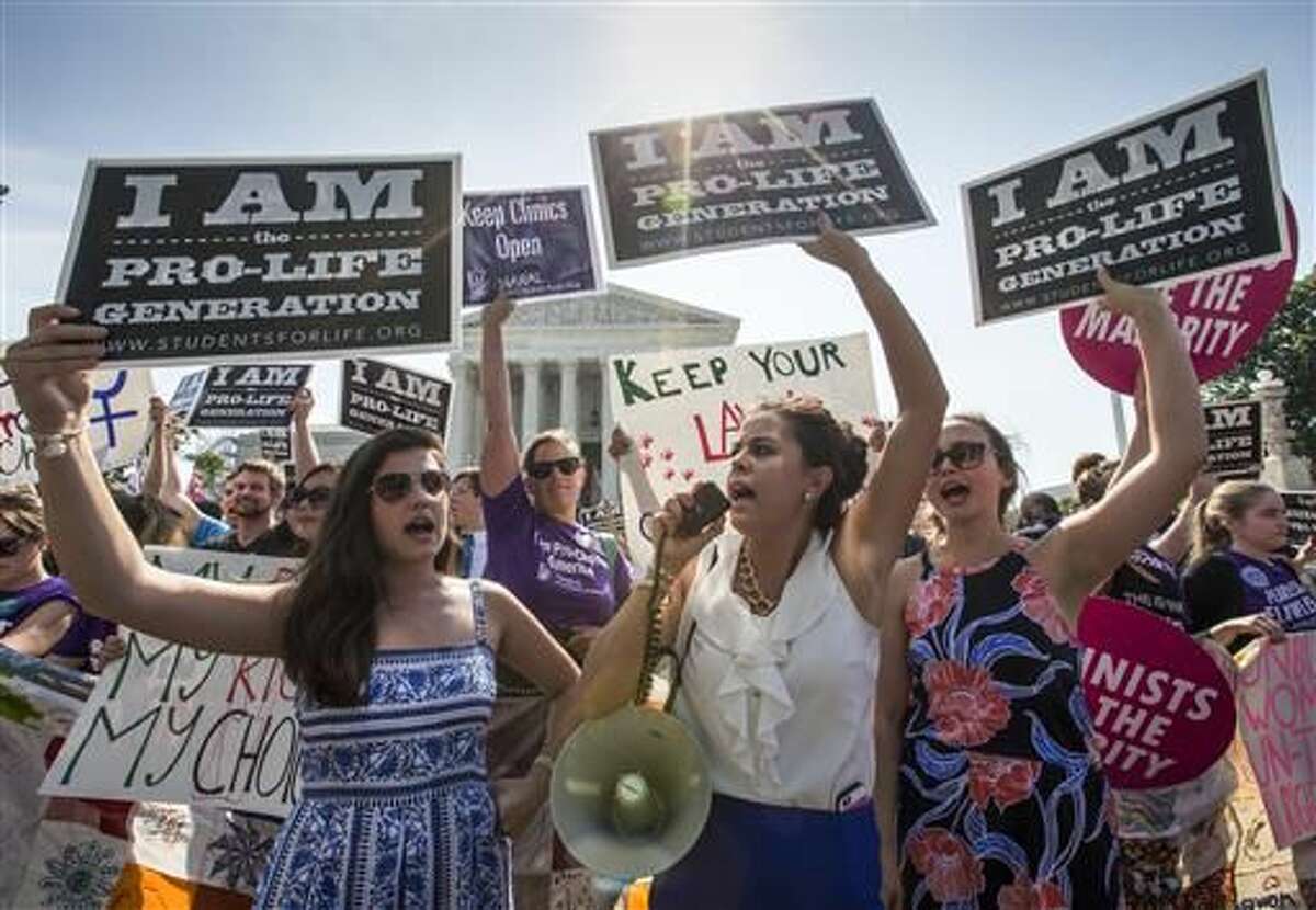 Reagan Barklage of St. Louis, center, and other anti-abortion activists demonstrate in front of the Supreme Court in Washington, Monday, June 27, 2016, as the justices struck down the strict Texas anti-abortion restriction law known as HB2. The justices voted 5-3 in favor of Texas clinics that had argued the regulations were a thinly veiled attempt to make it harder for women to get an abortion in the nation's second-most populous state. (AP Photo/J. Scott Applewhite)