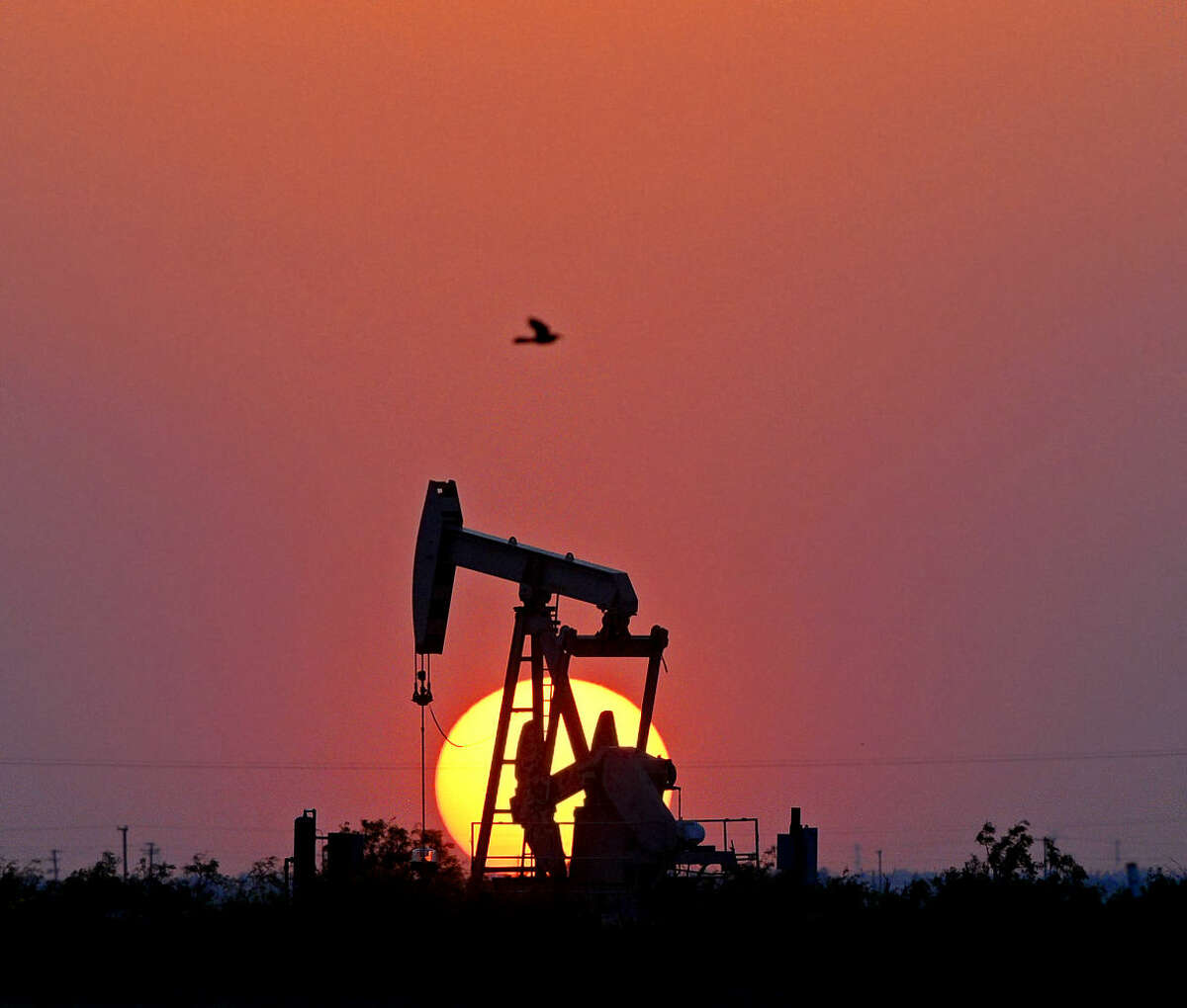 The sun sets behind a pumpjack on Highway 191 in Midland County, Thursday, April 28, 2016. James Durbin/Reporter-Telegram