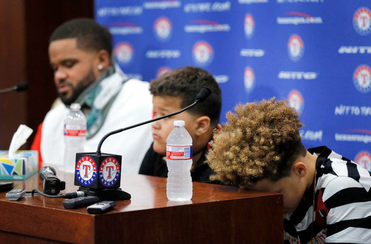 Jadyn Fielder, right, and his brother Haven, center, listen as their father, Texas Rangers' Prince Fielder, left, speaks during a news conference before a baseball game against the Colorado Rockies, Wednesday Aug. 10, 2016, in Arlington, Texas. Fielder, a 32-year-old slugger, is unable to come back after his second neck surgery. (AP Photo/Tony Gutierrez)