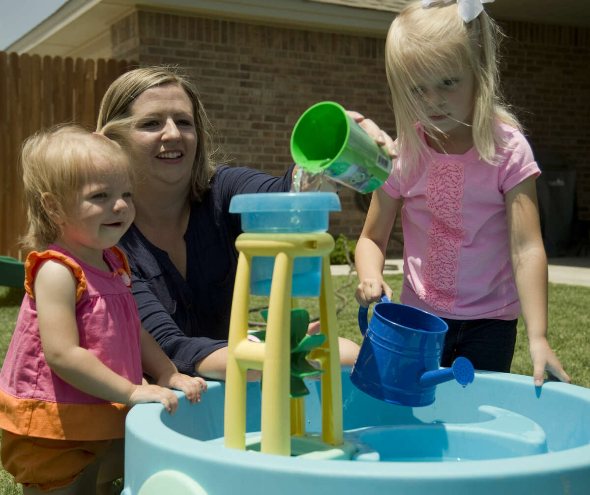 Rachel Biggerstaff and her daughters, Lilly, 1 and Susannah, 3, play in their backyard. Tim Fischer\Reporter-Telegram