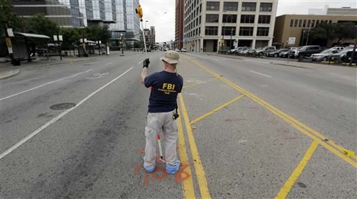 Investigators work in the area of downtown Dallas that remains an active crime scene, Saturday, July 9, 2016. Micah Johnson, an Army veteran, opened fire on police officers in the heart of Dallas Thursday, as hundreds of people were gathered to protest two recent fatal police shootings of black men, Philando Castile and Alton Sterling.
