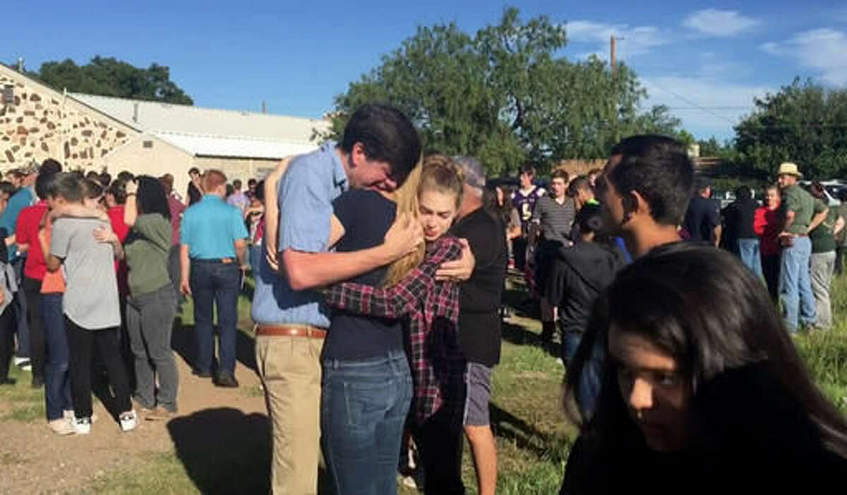 In this image made from a video by KWES-TV, people gather near the Alpine High School school campus after a shooting, in Alpine, Texas, Thursday, Sept. 8, 2016. A female student died of an apparent self-inflicted gunshot wound Thursday after shooting and injuring another female student inside the high school in West Texas, according to the local sheriff. (KWES-TV via AP)