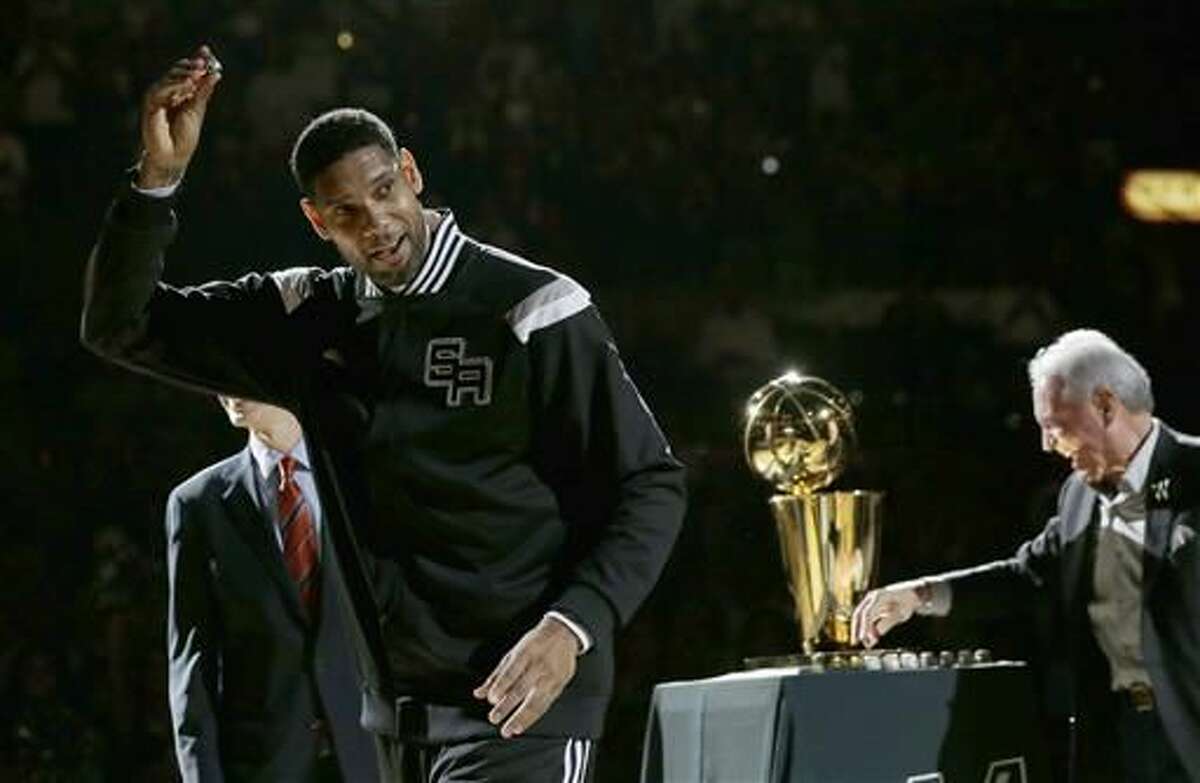 FILE - In this Oct. 28, 2014, file photo, San Antonio Spurs' Tim Duncan, left, holds up his 2014 NBA championship ring during a ceremony prior to an NBA basketball game between the Spurs and the Dallas Mavericks, in San Antonio. Duncan announced his retirement on Monday, July 11, 2016, after 19 seasons, five championships, two MVP awards and 15 All-Star appearances. It marks the end of an era for the Spurs and the NBA. (AP Photo/Eric Gay, File)  