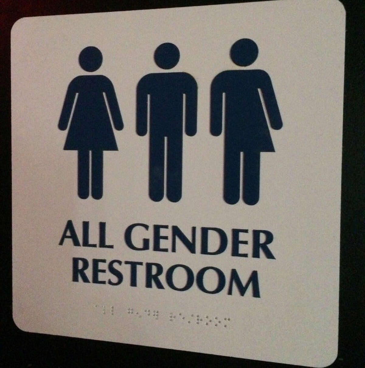 This May 11, 2014 photo shows an "All Gender Restroom" sign outside a bathroom in a bar in Washington. Confrontations have flared across the country over whether to protect or curtail the right of transgender people to use public restrooms in accordance with their gender identity. (AP Photo)