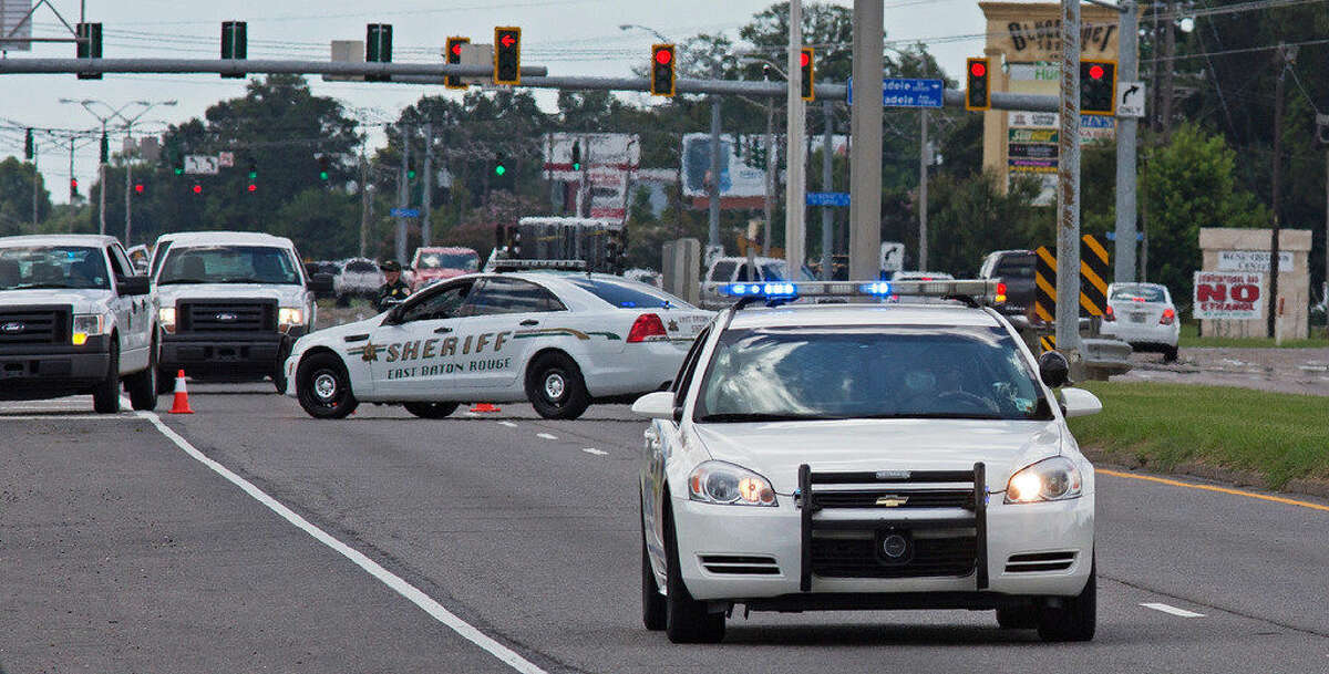 Baton Rouge Police arrive at the scene on Airline Highway after police were shot in Baton Rouge, La., Sunday, July 17, 2016. At least three officers are confirmed dead and at least three others wounded after the shooting, a sheriff's office spokeswoman said Sunday. One suspect is dead and law enforcement officials believe two others are still at large, the spokeswoman said. (AP Photo/Max Becherer)