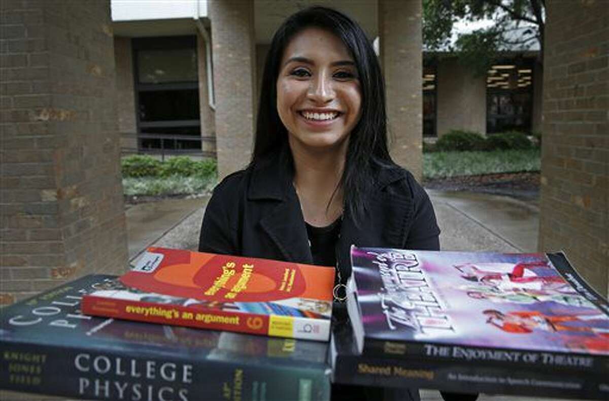 ADVANCE FOR MONDAY JUNE 13 AND THEREAFTER - In a Thursday, May 19, 2016 photo, Melisa Simon, 17, poses for a photograph with text books for college classes that she took at Eastfield College in Mesquite, Texas. She recently completed her associate degree at Eastfield College through W.W. Samuell Early College High School and will start a "TechTeach" program through Texas Tech in July that will allow her to get a bachelor's degree and teacher certification within one year. (Jae S. Lee/The Dallas Morning News via AP)
