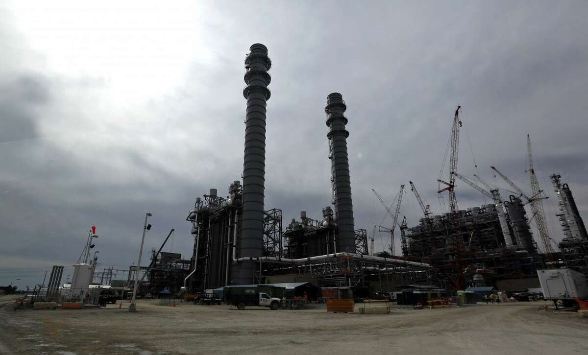 In this Oct. 21, 2013 photo, the H2S and CO2 absorber vessels are shown in silhouette at the Mississippi Power's Kemper County energy facility in central Mississippi near DeKalb. Construction continues at the power plant that is designed to use a soft form of coal called lignite in a gasification process to generate power. The plant, America?’s newest, most expensive coal-fired power plant is hailed as one of the cleanest on the planet, thanks to government-backed technology that removes carbon dioxide and keeps it out of the atmosphere. Once the carbon is stripped away, it will be used to do something that is not so green at all ?– extract oil. Power companies sell the carbon dioxide to oil companies, which pump it into old oil fields to force more crude to the surface. (AP Photo/Rogelio V. Solis) 