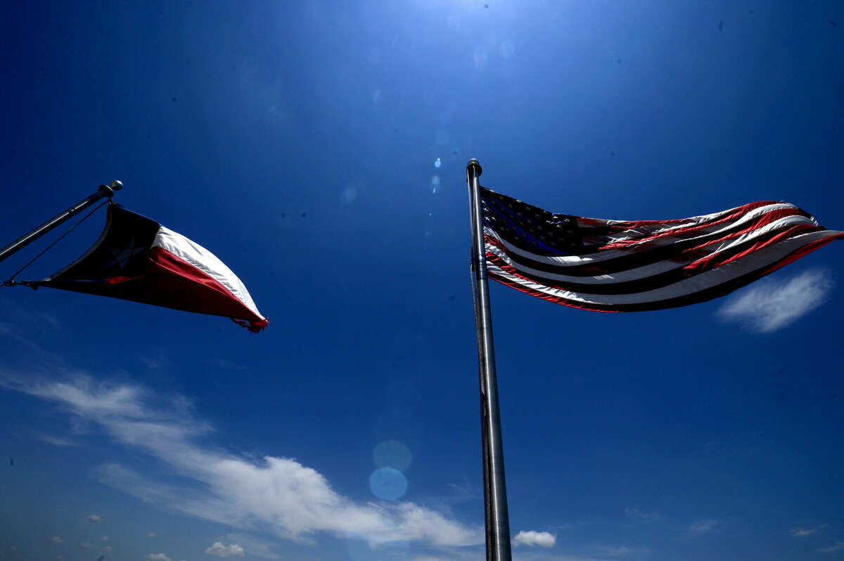 The flags of the United States of America and the state of Texas wave over the Midland County Public Library Centennial Branch, photographed Saturday, June 11, 2016. James Durbin/Reporter-Telegram