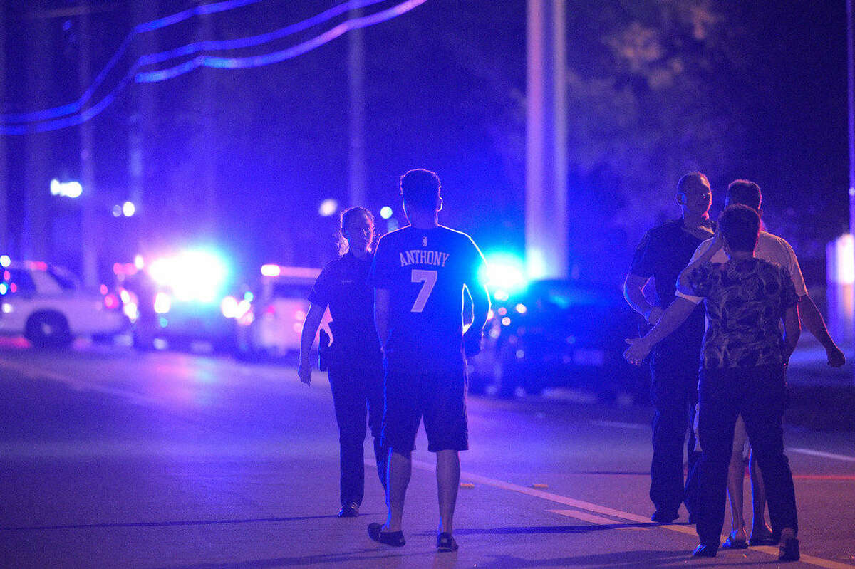 Orlando Police officers direct family members away from a shooting involving multiple fatalities at the Pulse Orlando nightclub in Orlando, Fla., Sunday, June 12, 2016. (AP Photo/Phelan M. Ebenhack)