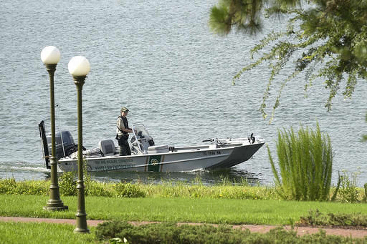 A law enforcement officer searches the Seven Seas Lagoon outside the Grand Floridian Resort & Spa on Wednesday, June 15, 2016, in Lake Buena Vista, Fla., after a two-year-old toddler was dragged into the lake by an alligator. (AP Photo/Phelan M. Ebenhack)