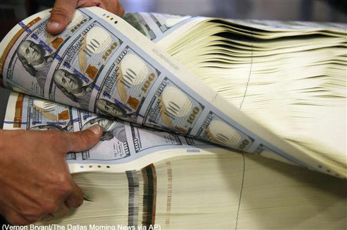 In a Wednesday, April 20, 2016 photo, Juan Reyna works on aerating a stack of $100 notes before a digital inspection at the Bureau of Engraving and Printing in Fort Worth, Texas. This helps keep the machine from getting a paper jam during the inspection process. (Vernon Bryant/The Dallas Morning News via AP)