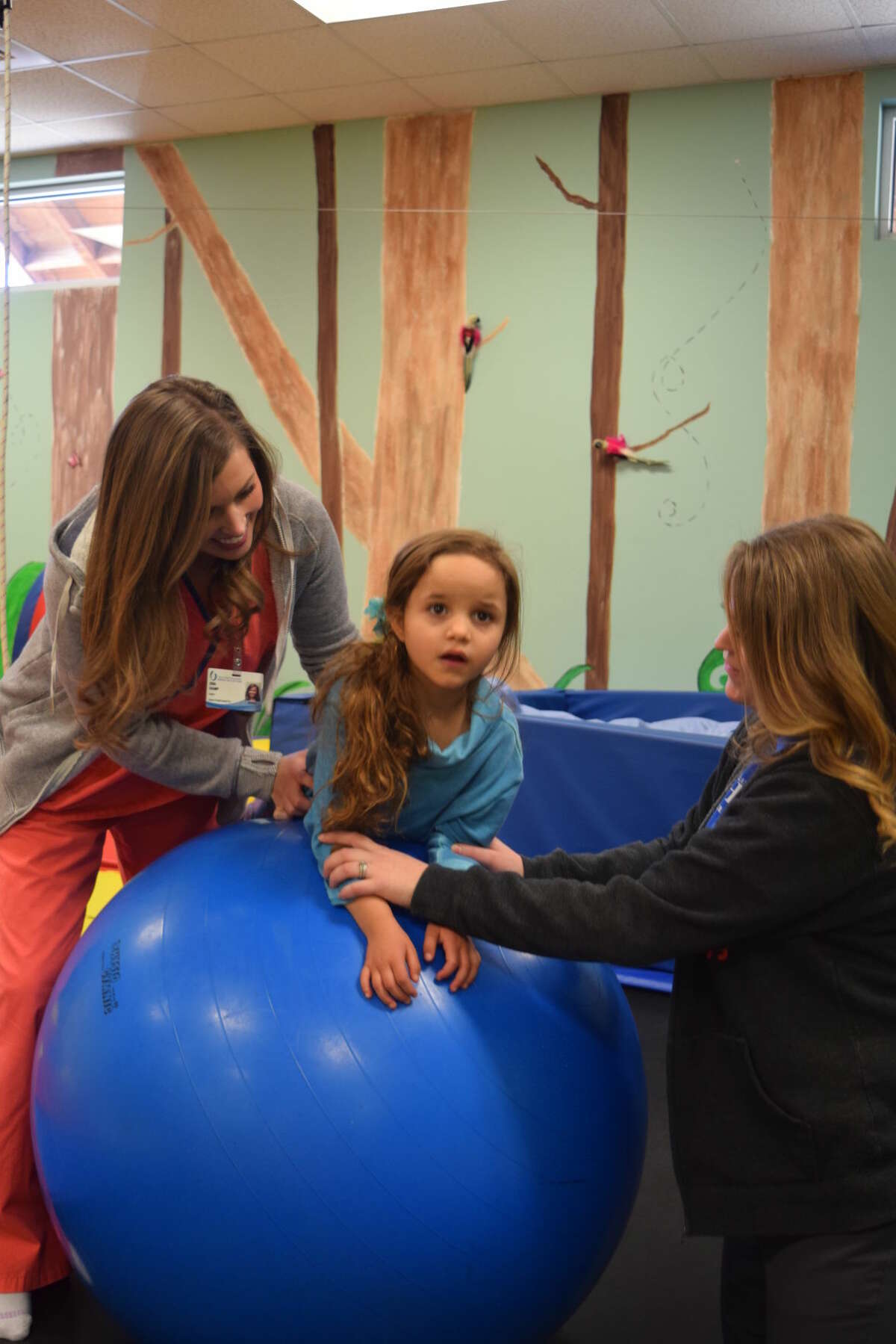 Emme Valenzuela receives occupational therapy with an intern, left, and therapist Jessica Neves, right, in a session in January at the Midland Children’s Rehabilitation Center.