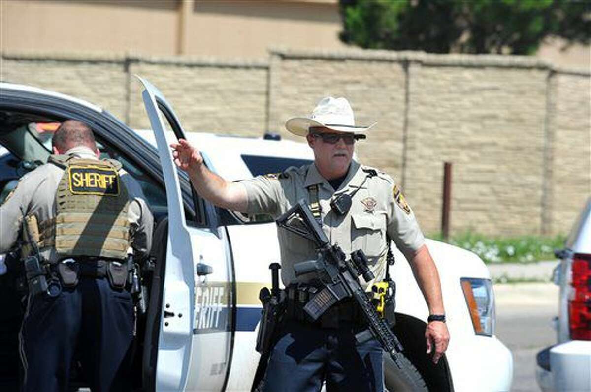 Heavily armed Amarillo Police and Randall County Sheriff's Deputies close a perimeter around the scene as SWAT teams and negotiations continue inside a Wal-Mart store where officers responded to a reported shooting, Tuesday, June 14, 2016, in Amarillo, Texas. (Michael Schumacher /The Amarillo Globe News via AP) MANDATORY CREDIT