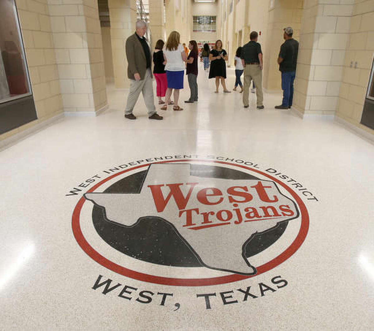 West High School principal Don Snook walks the main entrance to the newly completed West High and Middle school, Aug. 24, 2016, in West, Texas.. The $52 million combined campus is the first time that students are not in portable buildings or other sites since the deadly blast in West. Federal investigators in May announced the fire that caused the April 17, 2013, blast was intentionally set. (Jerry Larson/Waco Tribune Herald, via AP)