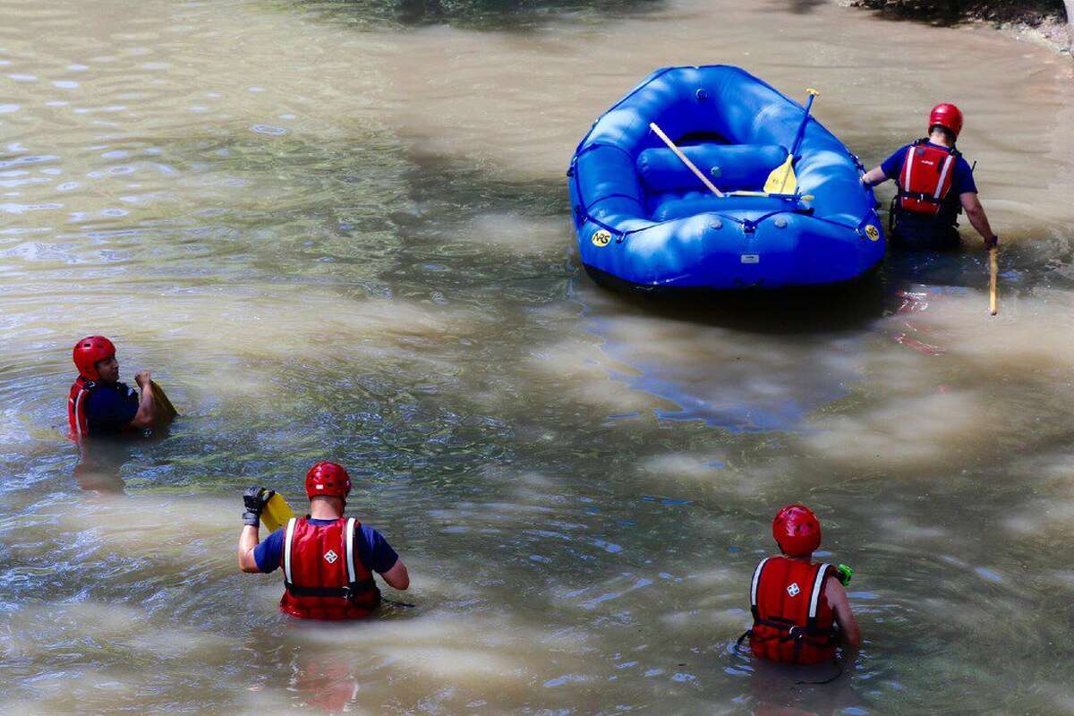 Searchers from various agencies, including Dallas-Fire Rescue teams, Dallas police, resume their search in the waters of Turtle Creek in Dallas on Wednesday, July 6, 2016, for the body of an off-dutySMU police officer who disappeared after reporting his car was being overtaken by water during a heavy storm early Tuesday as he was working a security job. (David Woo/The Dallas Morning News via AP)