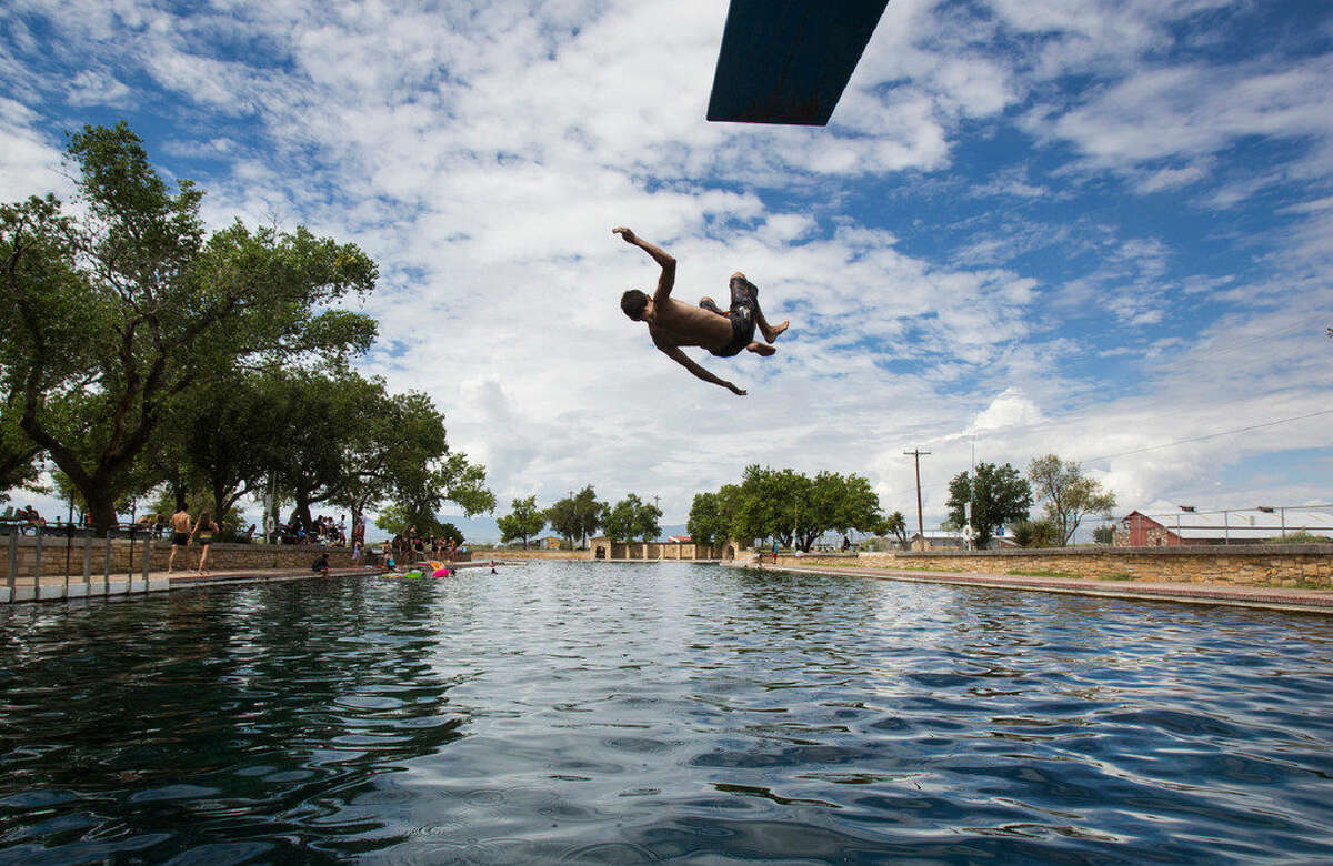 A In this Aug. 18, 2016 photo, a boy jumps off the diving board into 30 feet of water at the natural spring pool at the Balmoreah State Park in Balmoreah, Texas. The rise of fracking nearby the town has some community members worried about their drinking water and natural springs, which serve as a popular tourism destination helping drive the town's economy. 