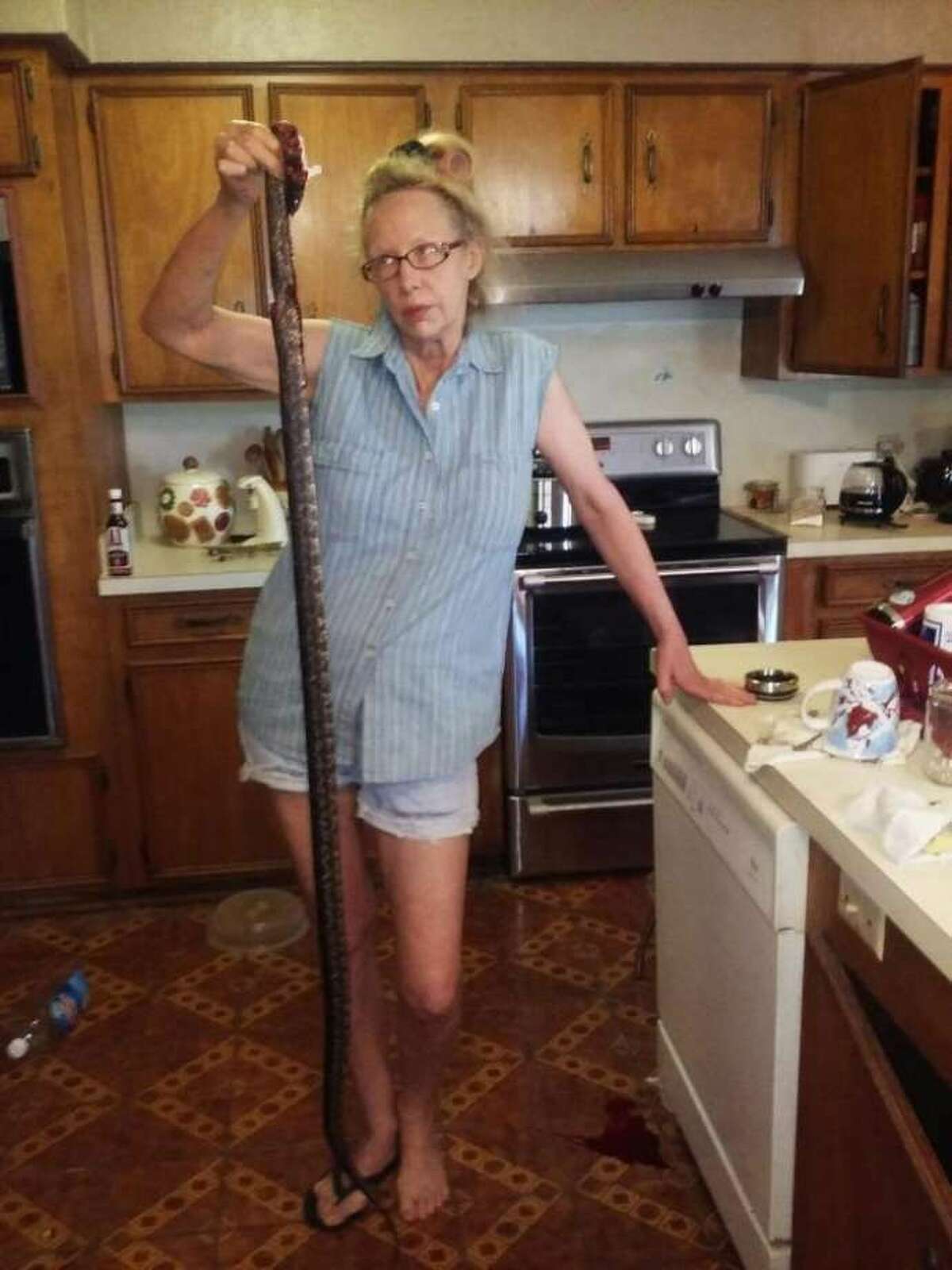 Deborah Burdette, from Willbarder County, and one of the snakes she found in her kitchen and killed.