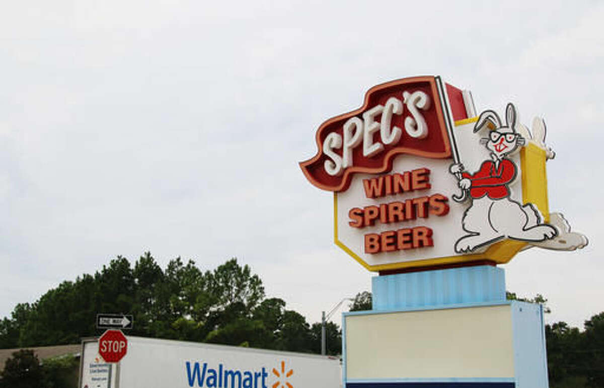 A Wal-Mart truck drives past a Spec's liquor store Aug. 26, 2016, on Loop 336 in Conroe, Texas, where the stores operate across the street from each other. Spec's, one of the state's largest liquor store chains, belongs to the Texas Package Stores Association, a trade group that has received court approval to join the Texas Alcoholic Beverage Commission in a lawsuit Wal-Mart has filed against the agency that dispenses liquor licenses. Wal-Mart wants to begin selling bottled liquor in Texas but contends it is prevented by TABC rules that are unconstitutional. (AP Photo/Michael Graczyk)