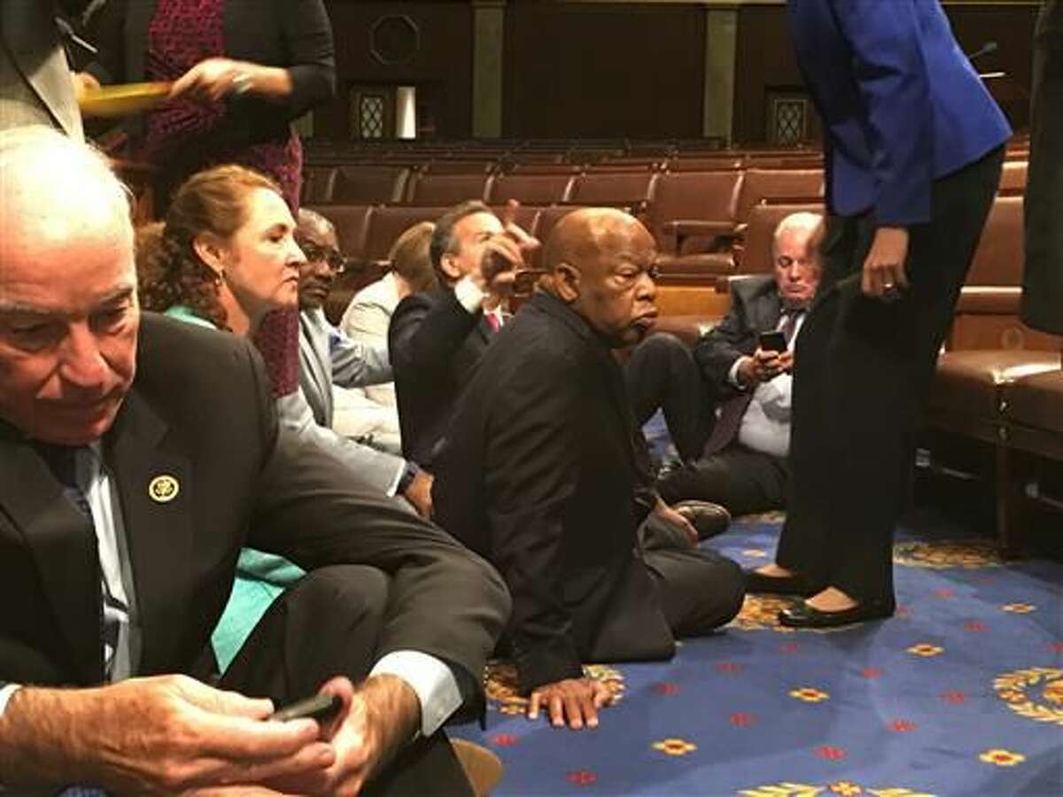 This photo provided by Rep. John Yarmuth, D-Ky., shows Democrat members of Congress, including Rep. John Lewis, D-Ga., center, and Rep. Joe Courtney, D-Conn., left, participate in sit-down protest seeking a a vote on gun control measures, Wednesday, June 22, 2016, on the floor of the House on Capitol Hill in Washington. (Rep. John Yarmuth via AP)