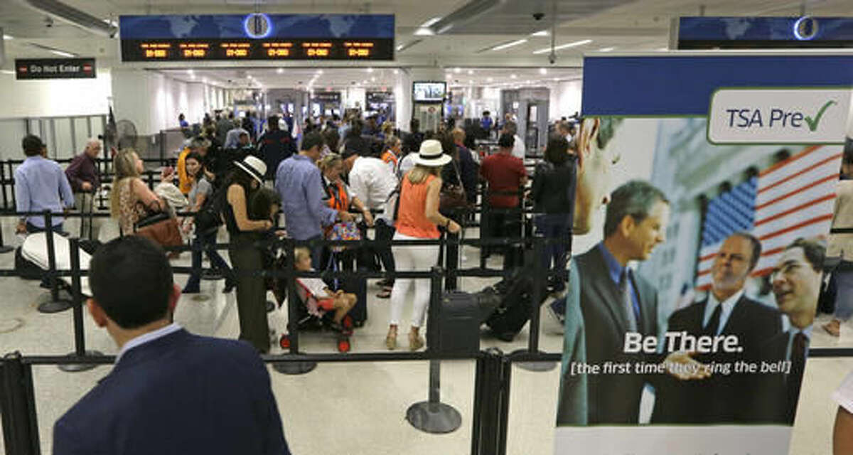 Travelers stand in line as they prepare to pass through a Transportation Security Administration checkpoint at Miami International Airport, Thursday, May 26, 2016, in Miami. Memorial Day weekend, the unofficial start of summer vacations for many and a busy travel period, serves as a crucial test for the TSA. (AP Photo/Alan Diaz)