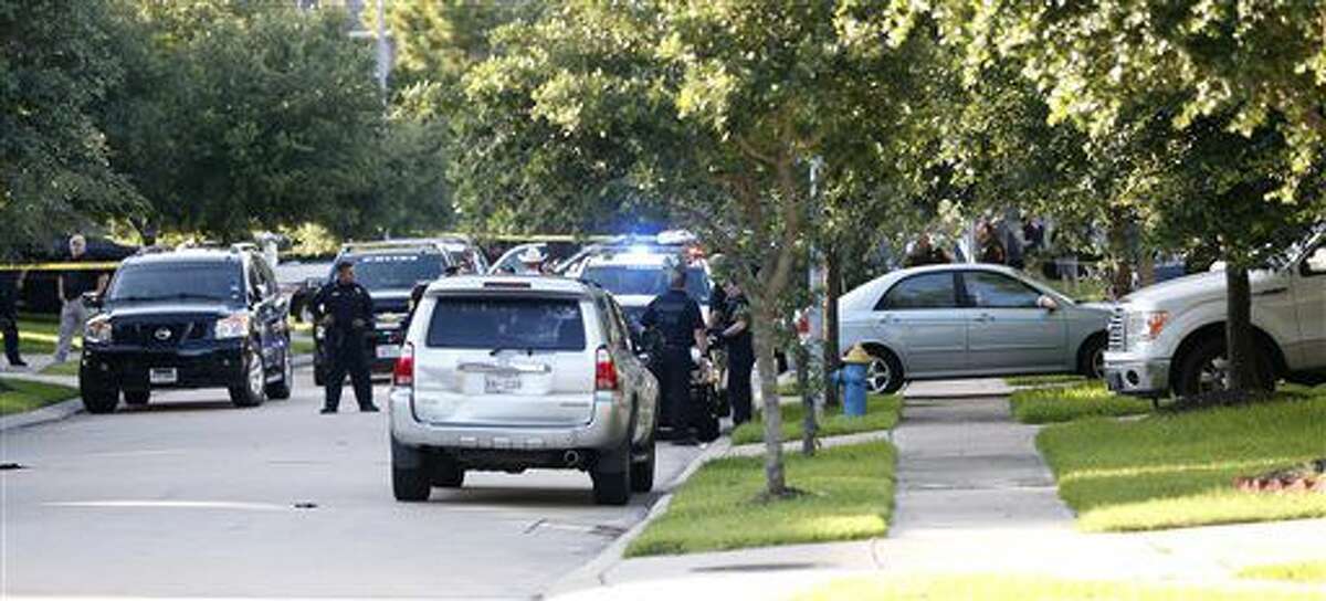 In this Friday, June 24, 2016 photo, Fort Bend County Sheriffs department investigate a shooting at Blanchard Grove and Remson Hollow in Katy, Texas. Officials said a woman shot her two adult daughters - killing one of them at the scene - before she was fatally shot by a responding police officer. (Karen Warren/Houston Chronicle via AP)