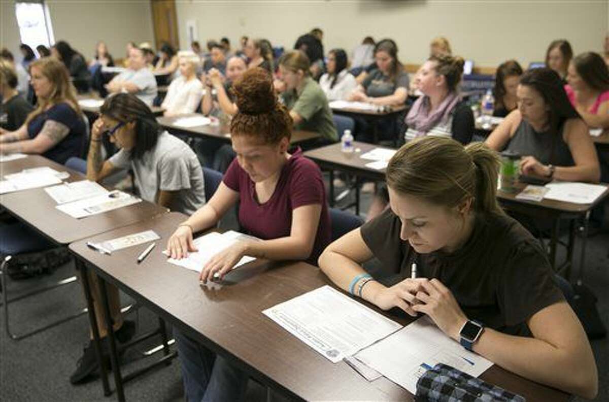 In a Saturday Aug. 20, 2016 photo, Women look at materials at an information session for female recruits at the Austin Police Department Recruiting Office in Austin, Texas. Austin police have credited use of social media and information sessions for women with helping attract more potential officers. (Jay Janner/Austin American-Statesman via AP)