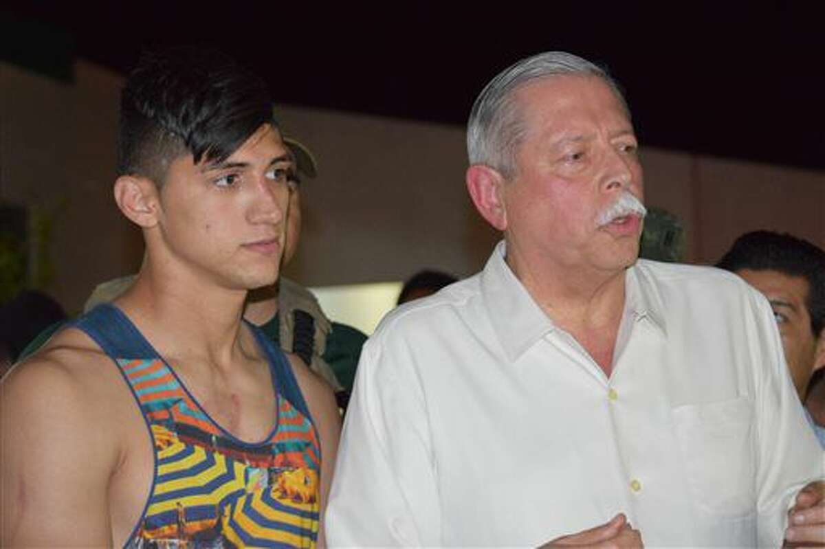 Mexican soccer player Alan Pulido, left, stands next to Tamaulipas State Gov. Egidio Torre Cantu after Pulido was rescued from kidnappers early Monday, May 30, 2016 in Ciudad Victoria, the capital of Tamaulipas State, Mexico. Mexican authorities say Pulido, a forward with Olympiacos in the Greek league, has been rescued safe and sound after an hours-long kidnapping in the northeast border state of Tamaulipas. (AP Photo/Alfredo Pena)
