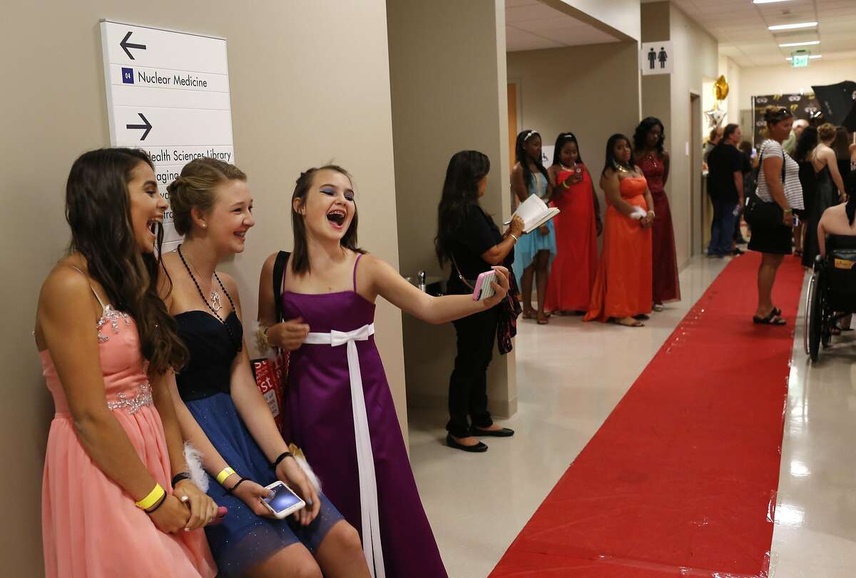 From left, Isabel Cervantes, 13, Camryn Taft, 13, and Nomi Solwren, 13, take a group selfie in the hallway during Kaiser Permanente Oakland's Pediatric Prom at Oakland Medical Center Sept. 24, 2016 in Oakland, Calif. The second annual dance was attended by around 100 teens who were otherwise unable to have the traditional school dance experience due to trauma or illness.