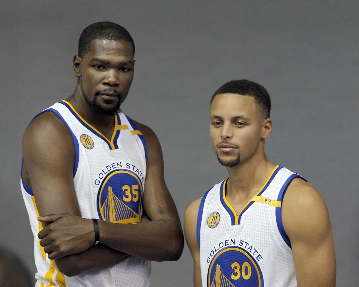 Kevin Durant (35) and Stephen Curry (30) pose for a photo during Warriors Media Day at their training facility in Oakland, Calif., on Monday, September 26, 2016.