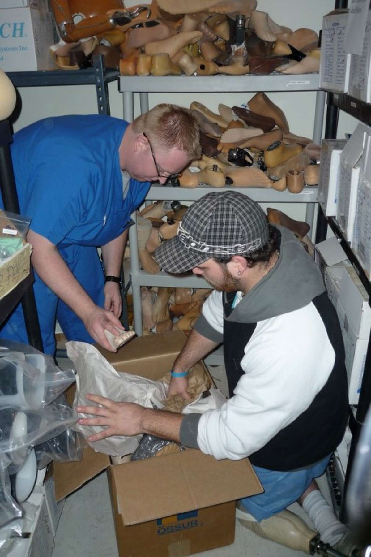Amputee & Prosthetic Center employees Nick Glebowski and Aaron Johnson pack prosthetic components to send to people that lost limbs in Haiti’s earthquake.