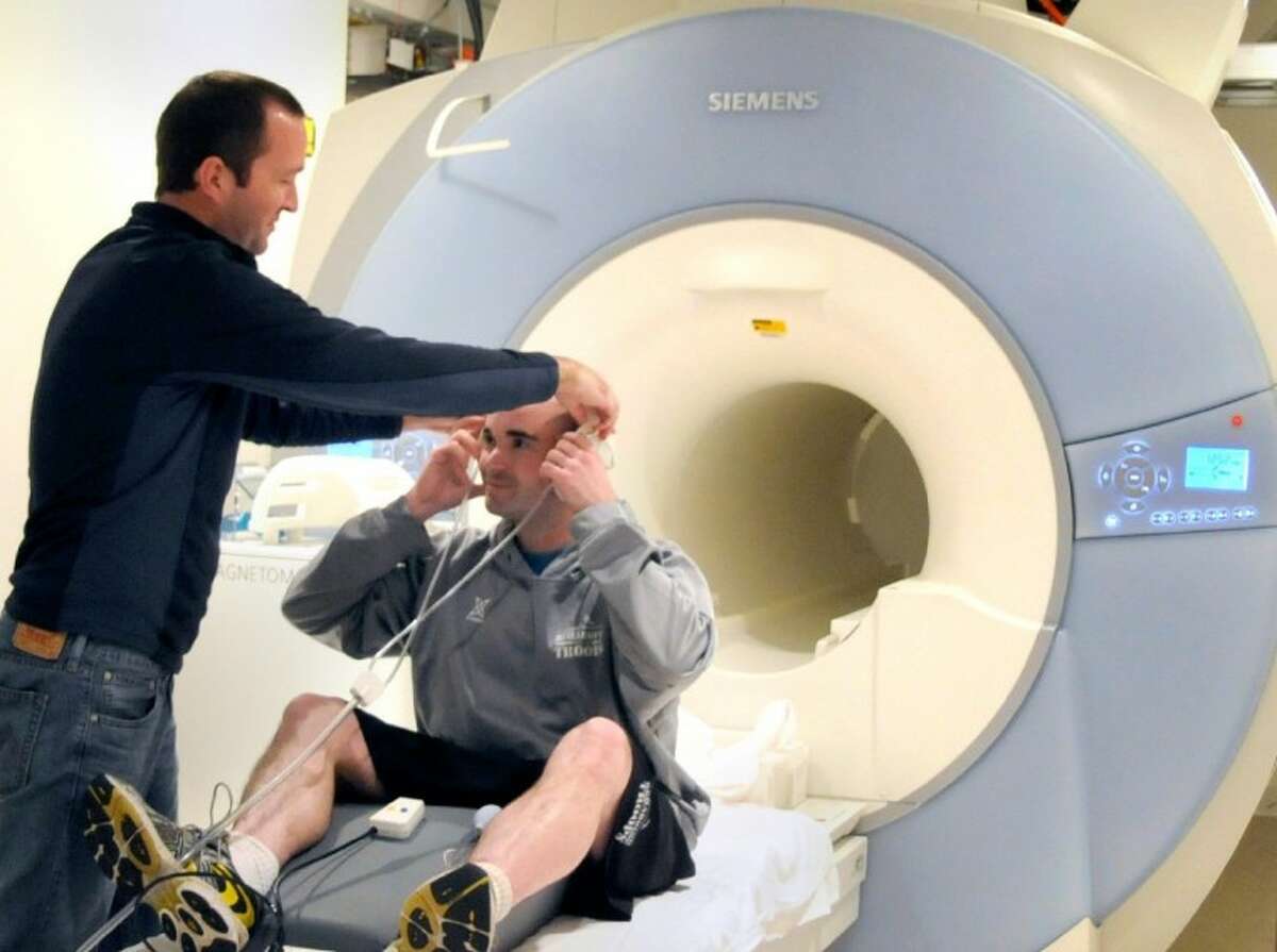 Research Coordinator Matthew Estey prepares Army Veteran Aaron Smelley for a functional Magnetic Resonance Imaging scan in order to learn how deployment affects the brain and to improve treatment of Post Traumatic Stress Disorder. (Photo by Agapito Sanchez, Jr., Baylor College of Medicine)