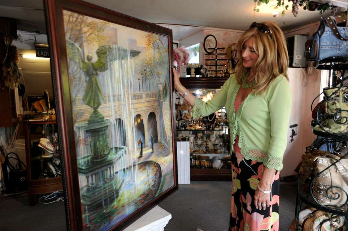 tSophia Scarpelli, owner of Sophia's on Liberty Way, in Greenwich, looks at one of the paintings by Judith Gwyn Brown that she will hang in her shop for Art to the Avenue on Tuesday, May 4, 2010.