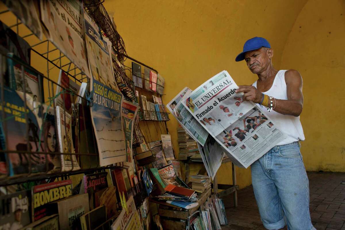 Saul Lambis ponders the Spanish headline "Agreement Signing" in a ﻿Cartagena, Colombia, newspaper on Tuesday. ﻿