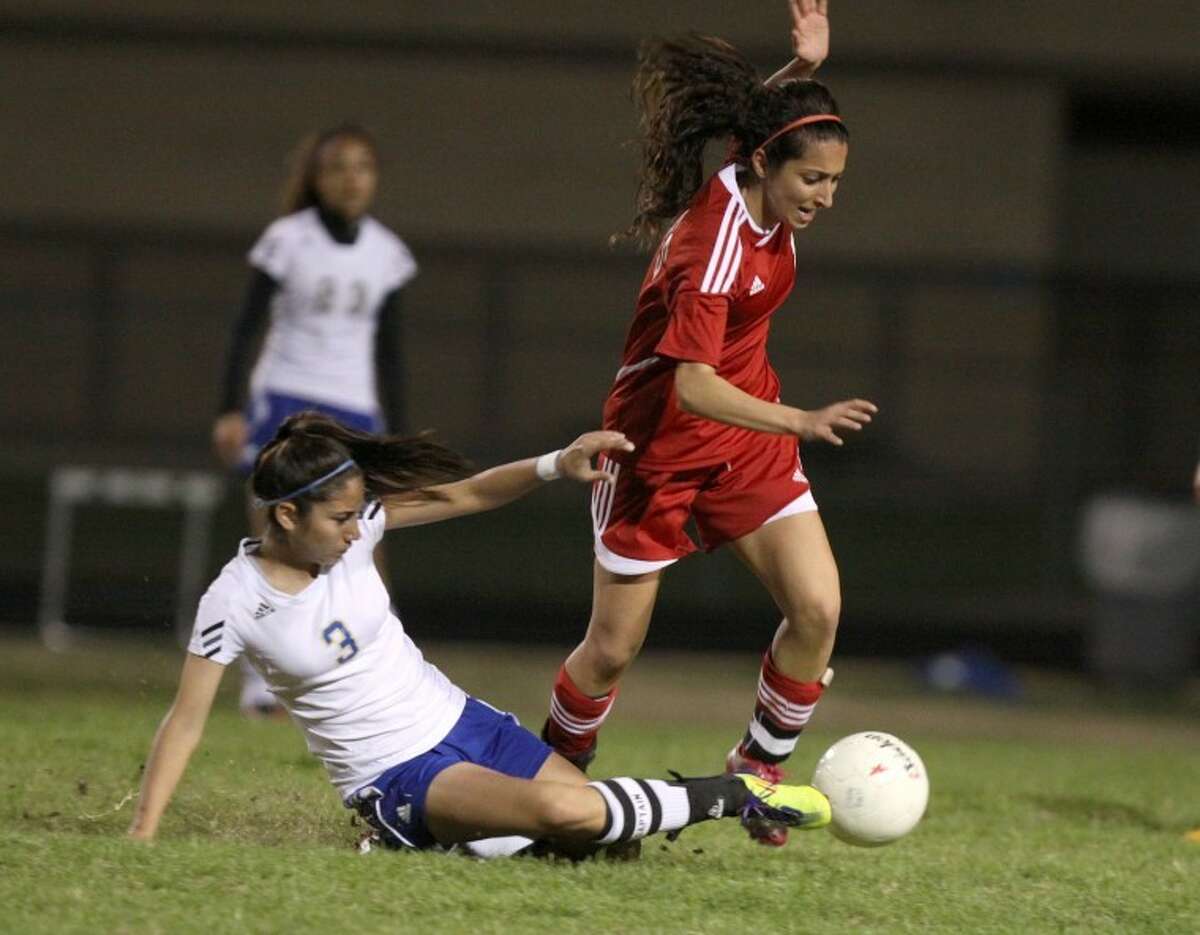 Elkins' Kristie Depuma tackles the ball away from Dulles' Lena Rafeedie during the teams' scoreless tie on Friday night. (Photo by Alan Warren)