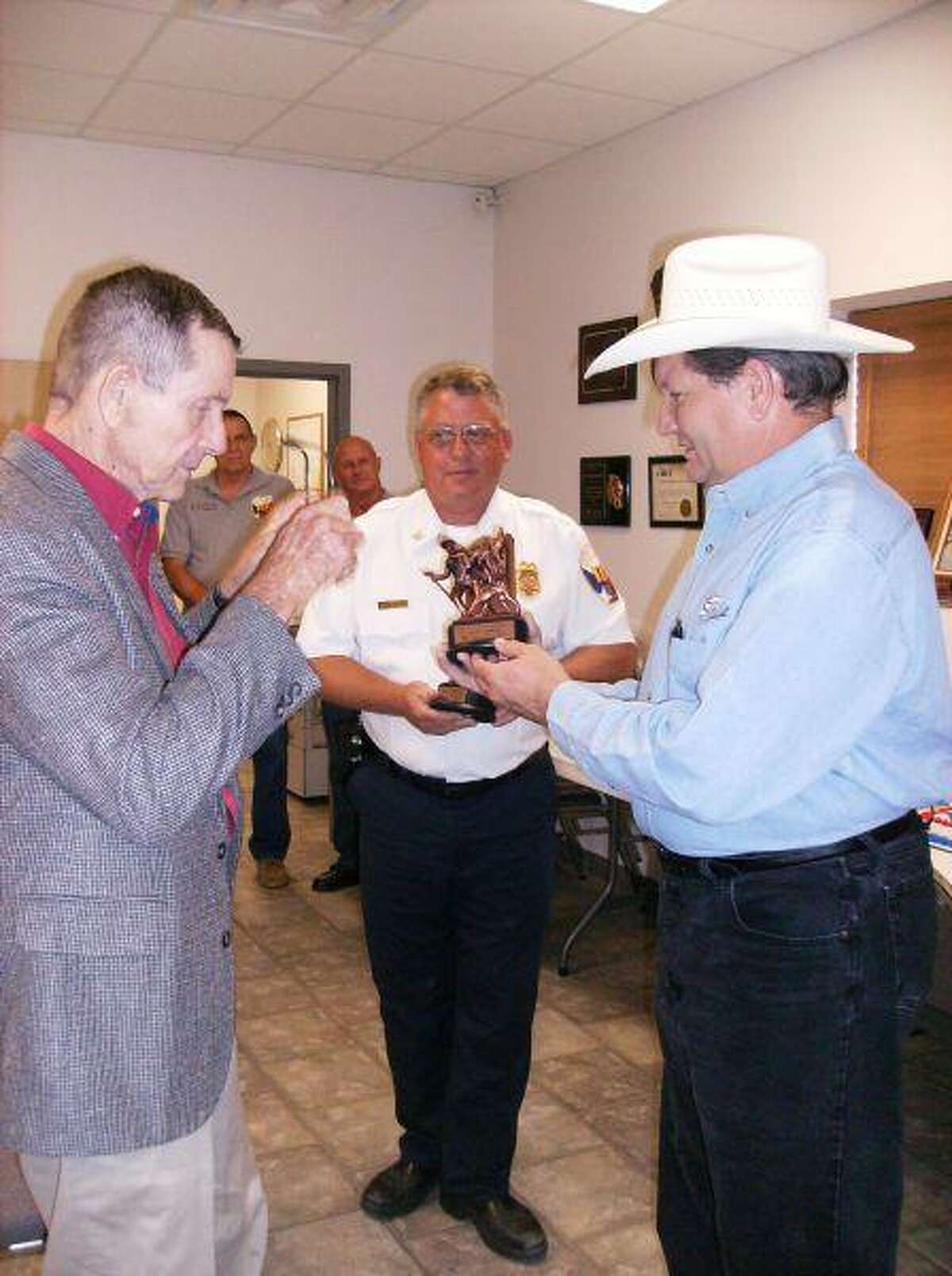 Crash survivor Bill Philpot, 70, of the Grangerland area, presents Perry Orrick, 45, with a New Caney Fire District Lifesaver award at an Aug. 26 ceremony attended by family and friends at the New Caney Fire Department.