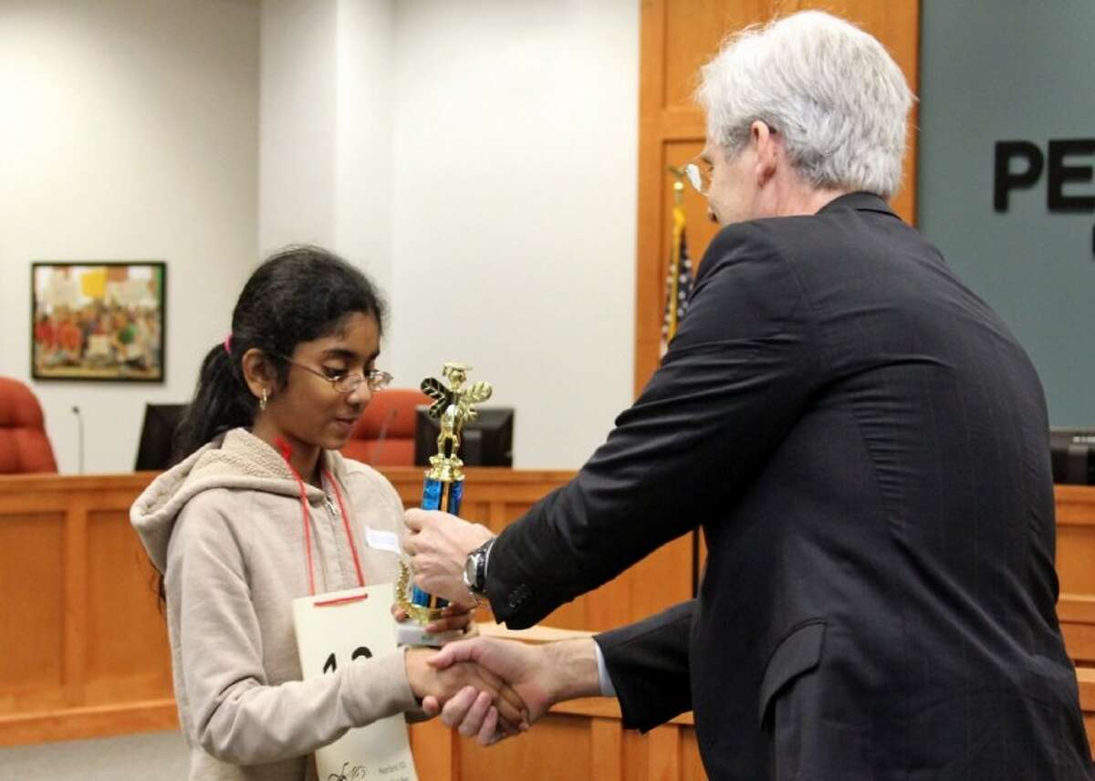 Shobha Dasari accepts the championship trophy from Superintendent Dr. John Kelly after winning the Pearland ISD district Spelling Bee Wednesday, Feb. 22.