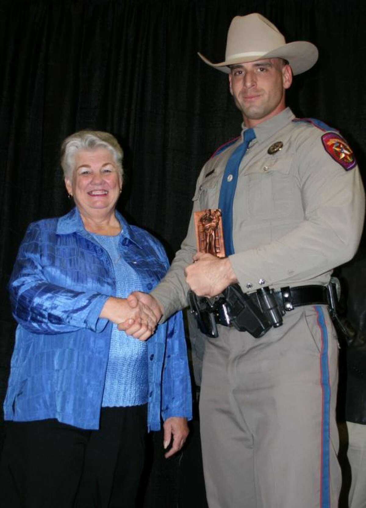 East Montgomery County Improvement District Chairman Connie Bloodworth presents DPS Trooper Derek Peterson with the Officer of the Year award for his department.