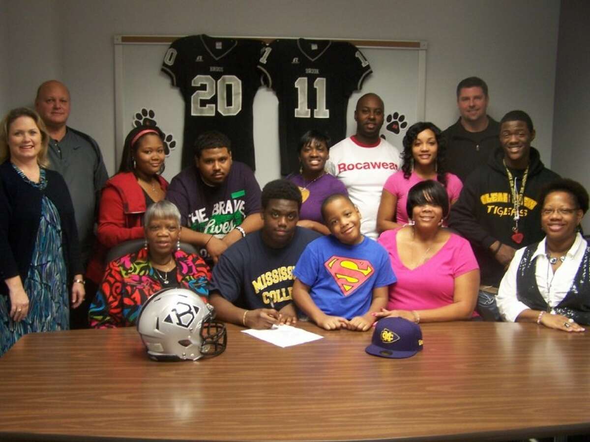 Clear Brook defensive lineman T.J. Johnson recently signed to play football at Mississippi College. Attending the signing were (seated left to rigth) Vernetta Henry, grandmother; T. J. Johnson; Lordan Warnell; Cathlyn Warnell, mother; (standing) Michele Staley, principal; Paul Lanier, head coach; Morgan Clay; Simon Gallardo; Linda Sprecher; Domanick Issac, Tara Mitchell; coach Lonnie Madison; Robert Johnson.