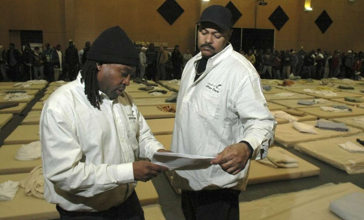 Thaddeus Hall and Maurice Gossett, both with Bread of Life After Dark program, prepare to bed down 150 homeless men at the St. John Church gym in downtown Houston on the night of the count.