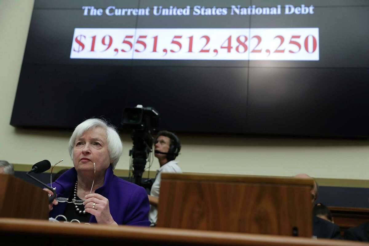 With the size of the current U.S. national debt is displayed behind her, Federal Reserve Board Chair Janet Yellen testifies during a hearing Wednesday before the House Financial Services Committee.