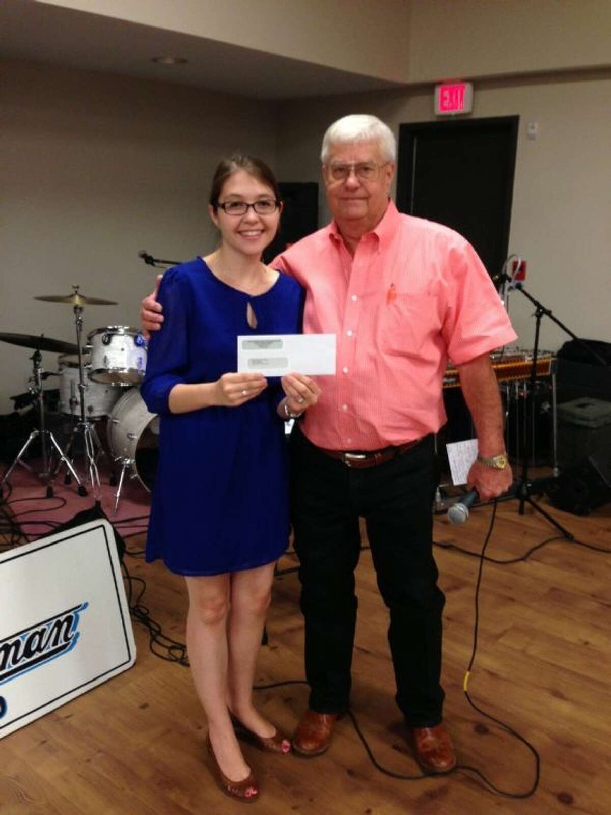 Anna Claire Croghan, executive director of The Friendship Center being presented with a check from Bill Robinson, president of the 60+ dance club